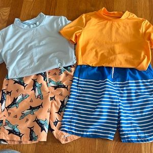 Set of two boys swim trunks with matching rash guards.